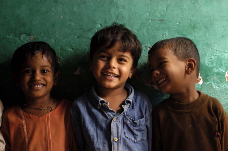Three smiling children standing together