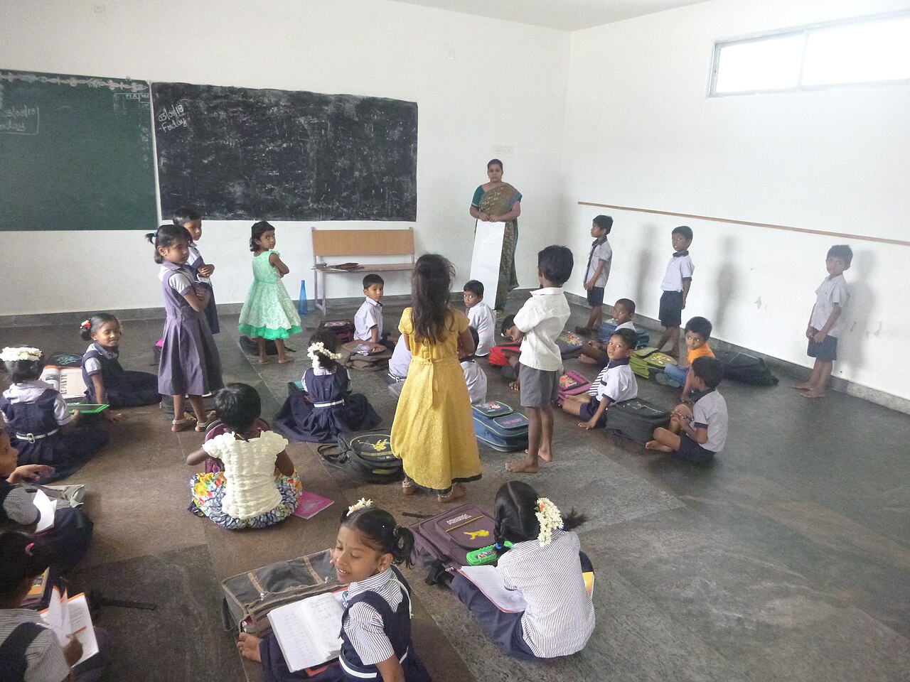 Children sitting together during a session in a community classroom