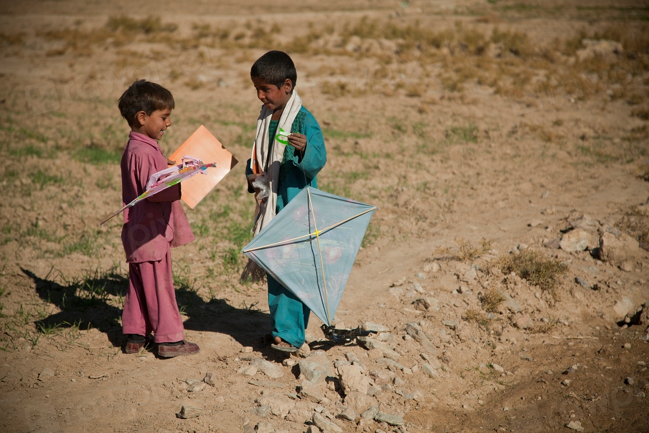 Children holding kites in an open field