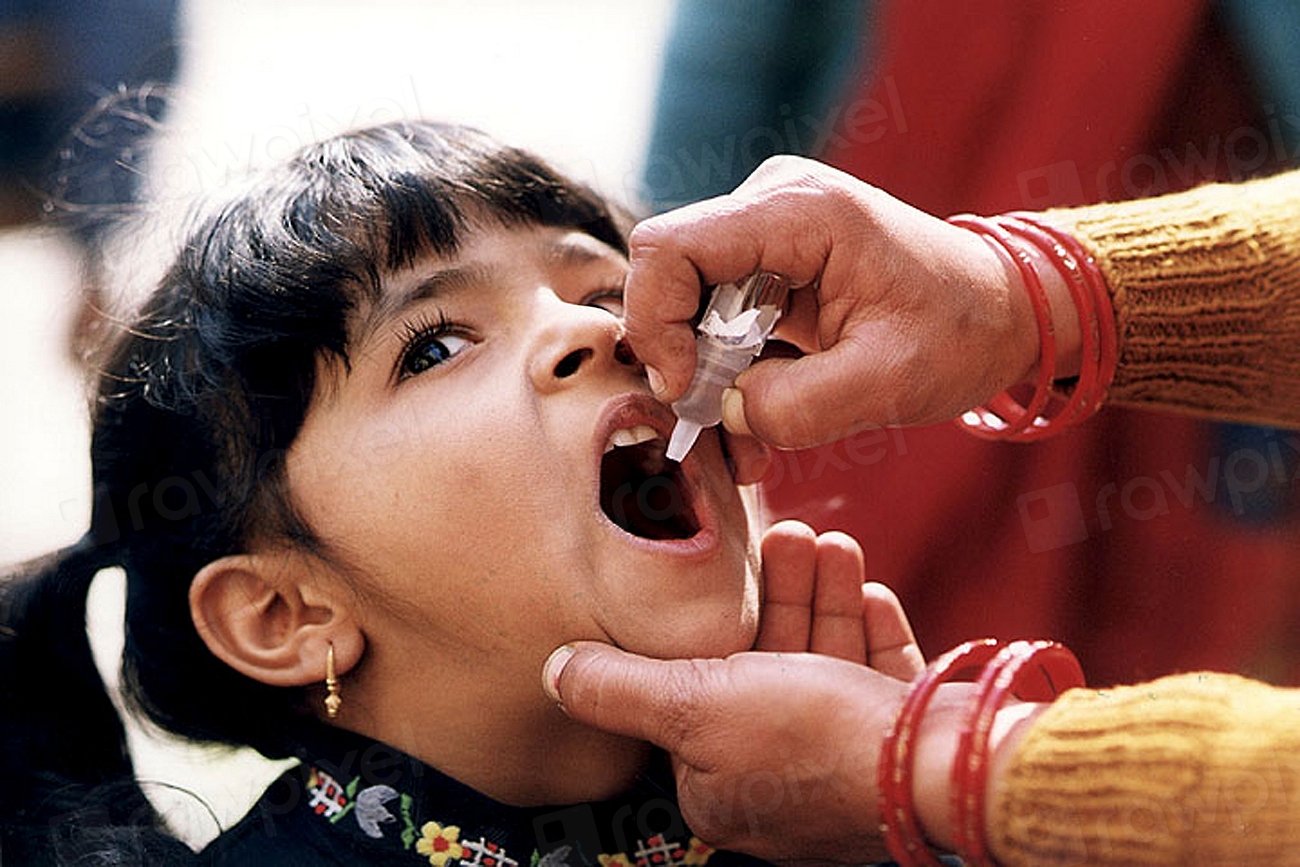 Health worker giving polio drops to a young child