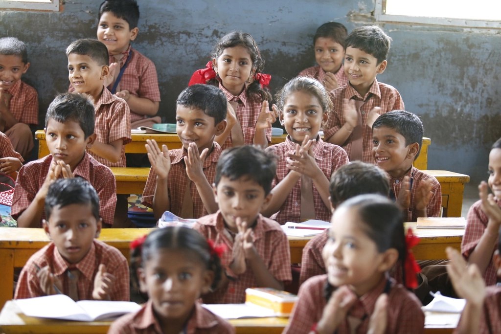 Children in school uniforms sitting together in a classroom